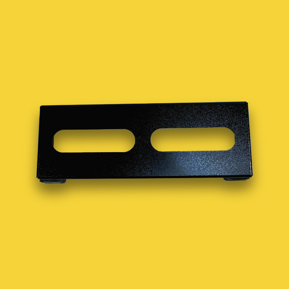 A top view of a black guitar effects pedalboard made of single sheet of aluminium with two long holes for cable management & 4 legs.